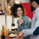Vegetarian african-american couple cooking salad in kitchen Vegetarian lifestyle. African-american couple preparing healthy salad with fresh vegetables in kitchen