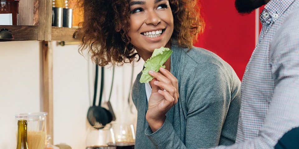 Vegetarian african-american couple cooking salad in kitchen